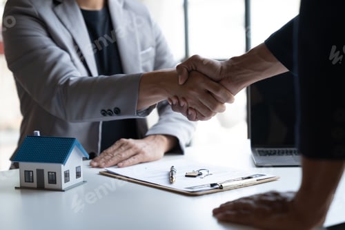 Preview: Two young Asian businessmen shake hands after signing a contract to invest in a village project. rea