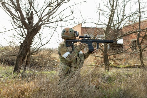 Preview: Army soldier shooting with firearm in battlefield.