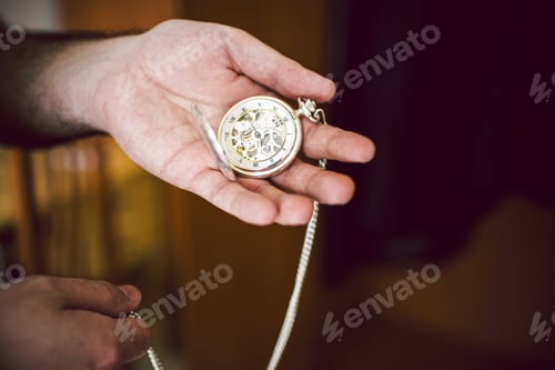 Preview: Hand Holding a Vintage Pocket Watch Indoors