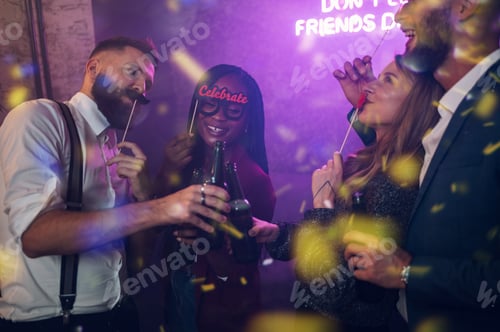 Preview: Happy group of friends dancing on a party in a club