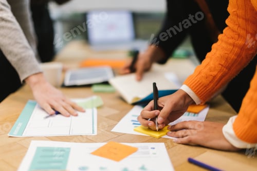 Preview: hands of colleagues working on projects using paper data and writing notes