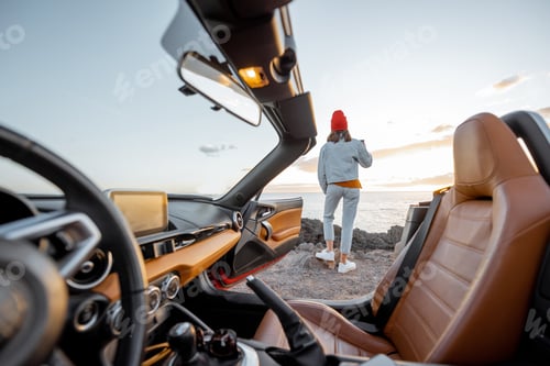 Preview: Woman traveling by car on the rocky ocean coast