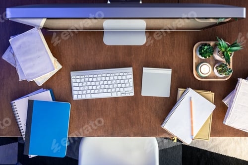 Preview: Student desk with computer, books and notepads on a wooden table.