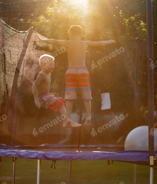 Preview: Jumping on trampoline near sunset on a summer evening in backyard