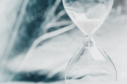 Preview: Time flows through a glass hourglass as sand trickles down in a calm, serene setting