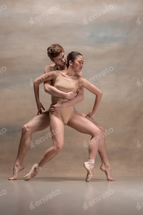 Preview: Couple of ballet dancers posing over gray background