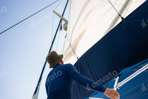 Preview: Close up of catamaran boat sailing worker raise the main sail of a yacht.