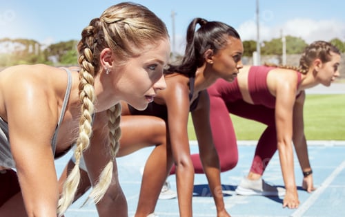 Preview: Three female athletes at the starting line in a track race competition at the stadium. Young sporty