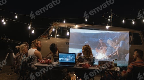 Preview: Group Of Friends Having Fun And Relaxing While Watching Movie On Screen On Van In Night Time