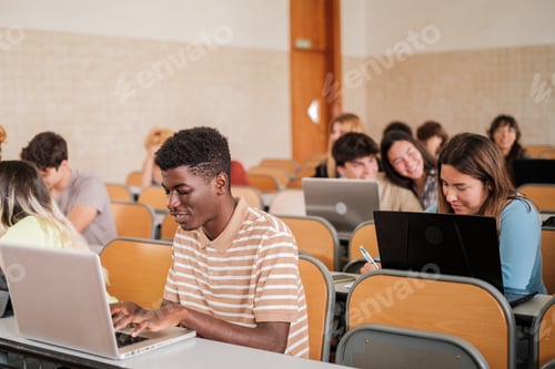 Preview: University students taking notes on the computer and paying attention in class