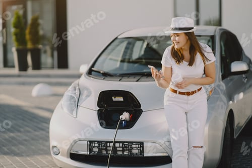 Preview: Woman charging electro car at the electric gas station