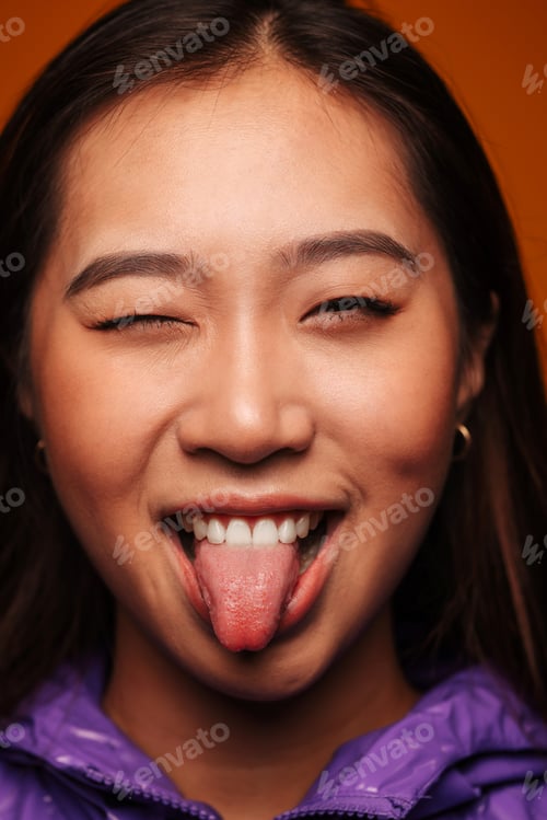 Preview: Funny young Chinese girl wearing modern clothes on yellow background.