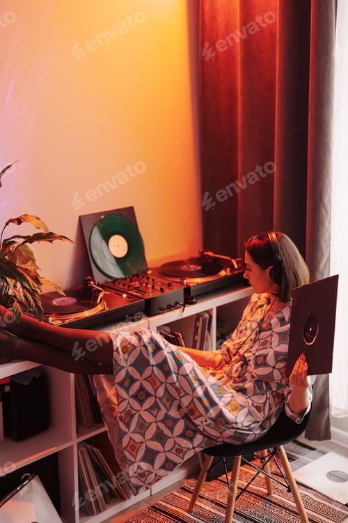 Preview: Relaxed young woman enjoying music on vinyl record player