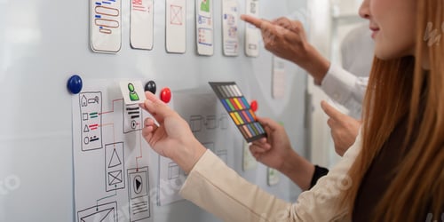 Preview: Collaborative UX UI team refining app designs on a whiteboard, dynamic creativity and teamwork