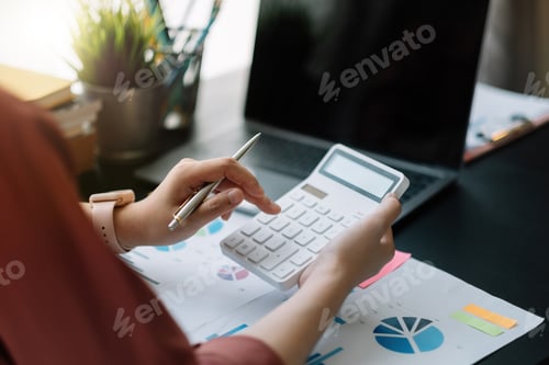 Preview: Business woman using calculator for do math finance on wooden desk in office, tax, accounting