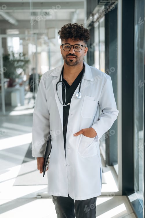 Preview: In white coat. Doctor is indoors in the modern building