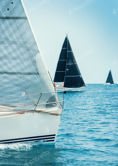 Preview: Sailboats races in regatta near Brindisi under blue cloudless sky. Boats have white and black sails