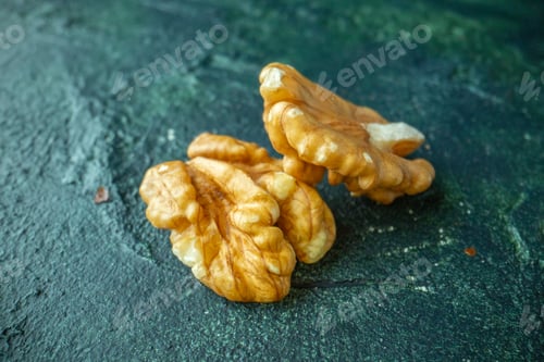 Preview: Top view of broken walnuts on blue and yellow mixed colors background with free space