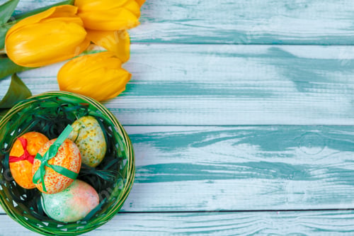 Preview: Easter eggs with tulips on blue wooden background