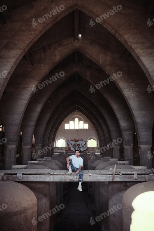 Preview: Man sitting on bridge inside old building