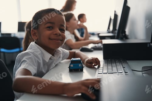Preview: Boy With Toy Car at Computer in Classroom