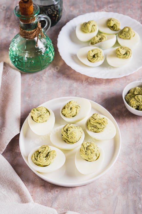 Preview: Avocado deviled eggs for appetizer on plate on table vertical view