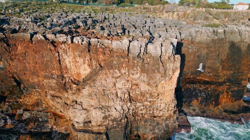 Preview: Cinematic panorama coastal rocks over ocean waves. Aerial rough volcanic cliffs