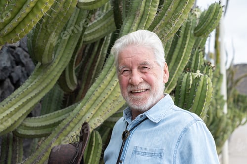 Preview: Portrait of an old smiling caucasian senior bearded man in outdoors enjoying a walk in public park