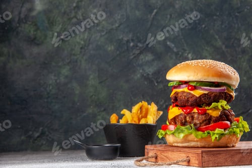 Preview: Homemade tasty sandwich on wooden cutting board fries on the left side on blurred background