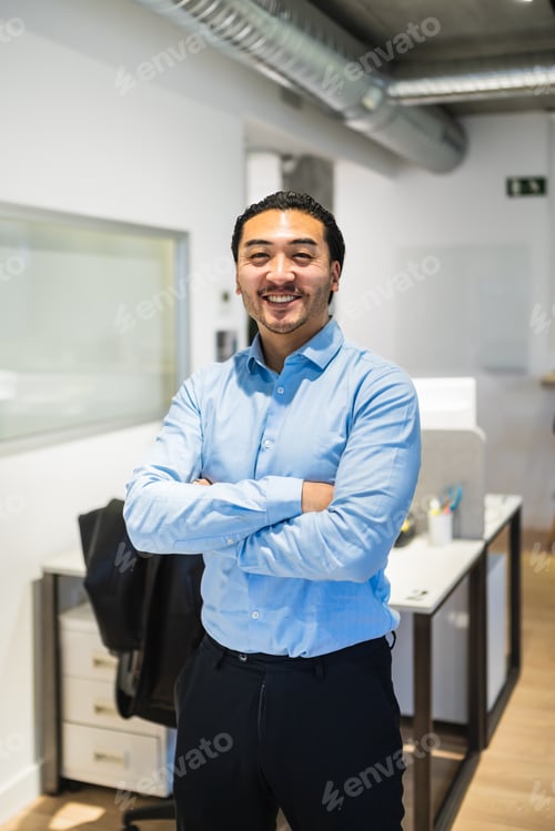 Preview: Confident asian businessman smiling with arms crossed in coworking office
