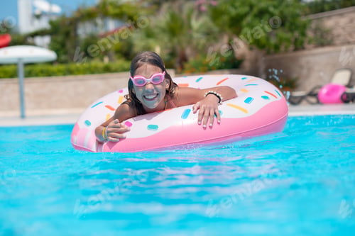Preview: little girl swimming in the pool on an inflatable circle