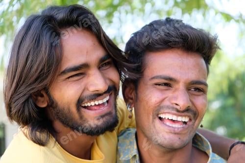 Preview: Portrait of a young cheerful Indian gay couple embracing and smiling in a park