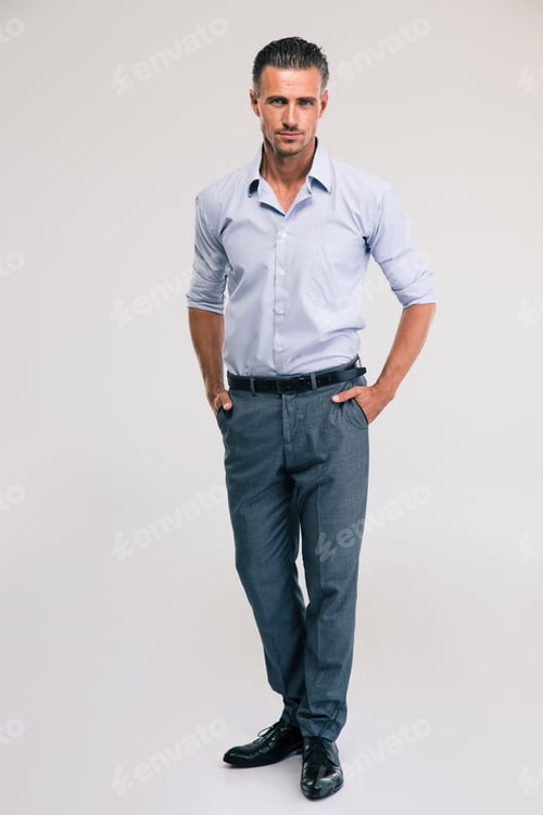 Preview: Full Length Portrait Of A Handsome Businessman Standing On Gray Background And Looking At Camera