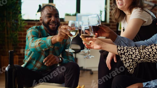 Preview: Smiling colleagues throwing apartment party, eating snacks