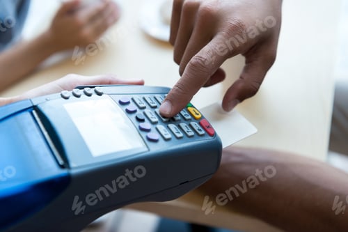 Preview: close-up partial view of person paying by credit card and terminal
