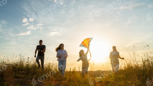 Preview: Family Fun Outdoors Running in Grassy Field at Sunset