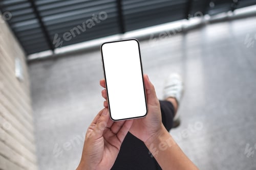 Preview: Top view mockup image of a woman holding mobile phone with blank white screen