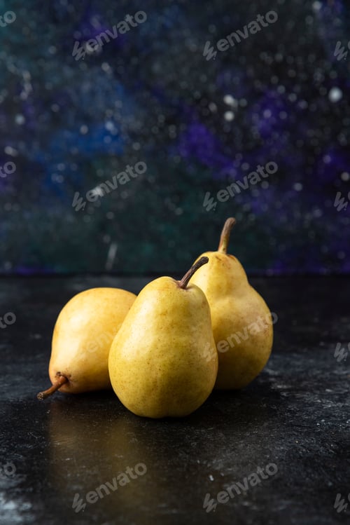 Preview: Three tasty yellow pears placed on black surface