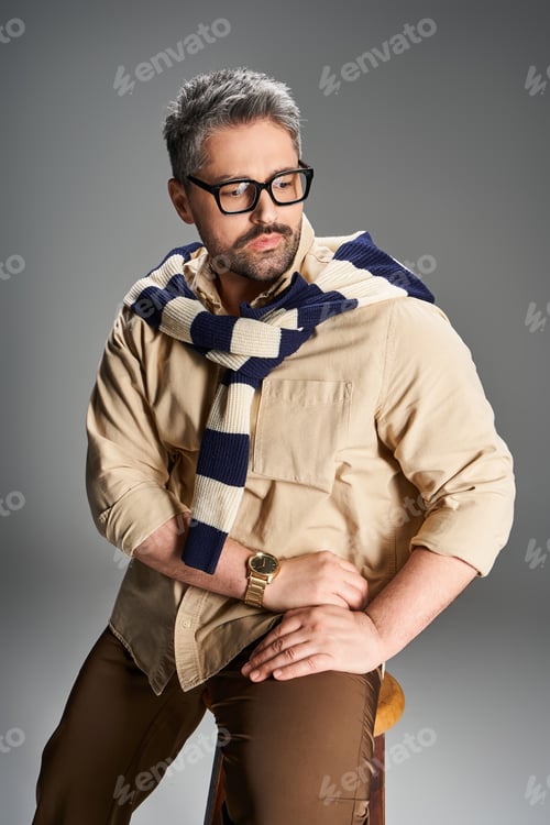 Preview: Stylish man with glasses showcases elegant fashion in modern studio setting