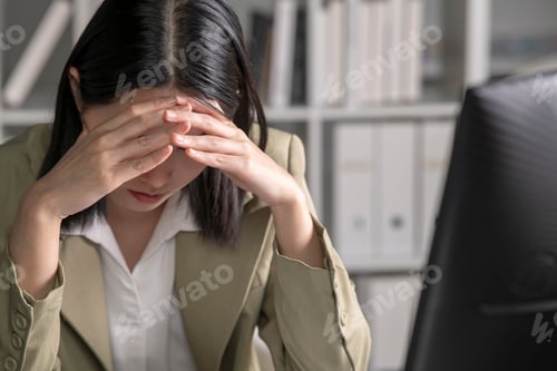 Preview: Tired young businesswoman working at office