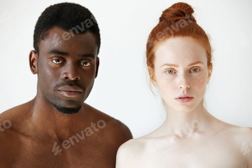 Preview: Black and white. Headshot of African man and Caucasian woman standing shirtless and looking at the c