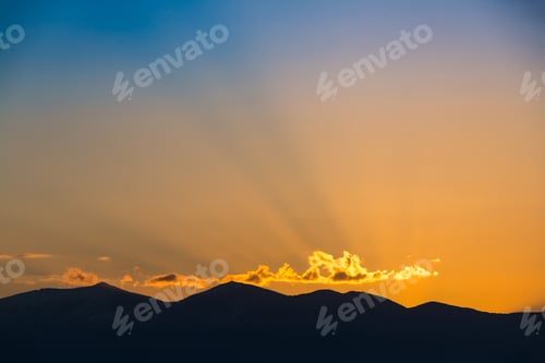 Preview: Majestic vivid sunset/sunrise over dark mountains silhouettes