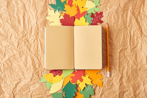 Preview: flat lay with blank notebook, pencil and colorful handcrafted paper leaves on crumpled paper