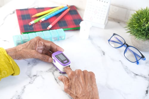 Preview: senior women hand using pulse oximeter on table