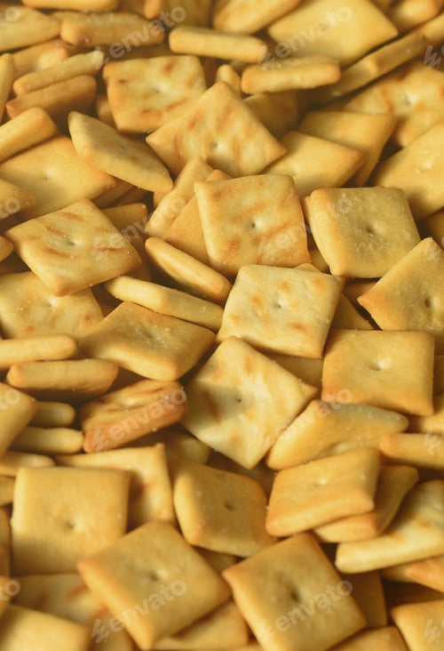Preview: Background texture of small edible squares baked from dough and sprinkled with salt. A lot