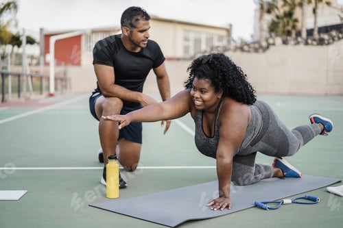 Preview: African curvy woman and personal trainer doing pilates workout session outdoor