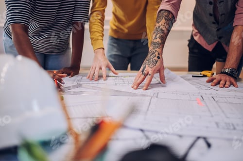 Preview: Multiracial team of architects having a meeting while using blueprints