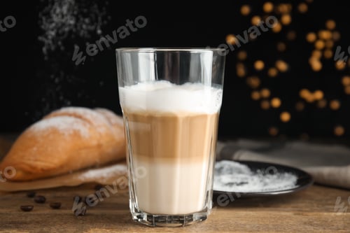 Preview: Delicious latte macchiato, croissant and scattered coffee beans on wooden table