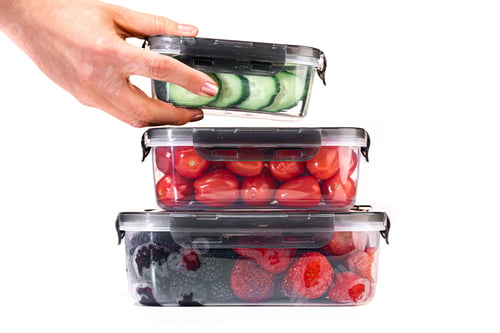 Preview: Closeup of plastic containers filled with tomatoes, cucumbers, blackberries, and strawberries