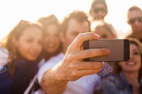 Preview: Group of friends taking selfie on beach